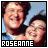 Two side-by-side animated frames of a pixelated photo showing two people smiling, with text at the bottom reading "ROSEANNE" in white on black and light blue on dark gray backgrounds.