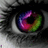 A pixelated close-up of an eye with a rainbow-colored iris, surrounded by dark and gray tones.