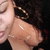A person with dark hair and gold hoop earrings appears in a of four , with the bottom-right showing a blank gray space