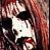 Two side-by-side animated frames of a person with long hair and dark clothing against a gray background, showing subtle facial expression changes between the left and right frames.