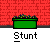 Green rectangular planter with purple flowers on gray ground against red brick wall, labeled 'Stunt' with white text, featuring animated character head and green hand above planter.