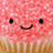 Pixelated pink cupcake with black dot eyes and curved smile, brown paper liner, and white sprinkles on top, displayed in a with one empty