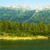 Pixelated landscape with green fields, blue water, and light sky, rendered in low-resolution style with visible pixelation.
