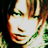Pixelated close-up of a person's face with visible eyes, nose, and mouth against a dark background with green accents.