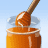 Animated sequence showing honey being lifted from a jar with a wooden dipper, transitioning to green apples and a sliced apple.