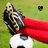 Pixelated image of a figure in dark armor holding a red cape, standing on a white and black soccer ball against green background with small checkered symbol.