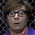 Pixelated close-up of a person with dark curly hair, glasses, and a purple garment, set against a dark patterned background.