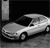 A grayscale pixelated image of a sedan car positioned at an angle, with visible wheels and windows against a dark background.