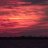 A static image composed of horizontal bands of red, pink, and orange pixels with a central bright white stripe, set against a dark background.