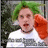 Pixelated image of a person with green hair, red eyes, and an open mouth wearing a white shirt with a red sleeve, set against a blurred green and gray background.