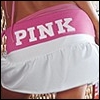 A close-up of a person wearing a pink and white top with the word PINK in large white letters on the pink section.