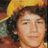 A pixelated image shows a person with curly dark hair wearing a yellow hat on the left, next to a red background with white text reading 'nick jonas <33' on the right.