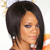 A pixelated close-up of a person with long dark hair, light skin, and a neutral expression wearing a white and orange garment.