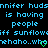 Pixelated text repeats across a black background with two green heart symbols at the bottom right.