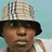 Four-frame contact sheet of a person wearing different hats and clothing across sampled frames, with text overlay in the top-right frame.