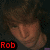 Pixelated image of a person with brown hair and a light brown face, red text reading "Rob" in the bottom-left corner, dark background with scattered red and black pixels.