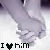 Two side-by-side animated frames showing hands holding with text below each frame reading "I [heart] him" in pixelated font, one heart black and the other pink.