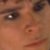 A pixelated close-up of a human face showing eyes, nose, and mouth with brown skin tones.
