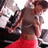 A person in a gray crop top and red pants stands with arms crossed, viewed from above against a blurred background.