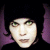 Pixelated static image of a person's face with dark hair and purple side elements against black background, rendered in low-resolution 256x256 pixels.
