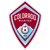 A shield-shaped icon with layered borders in red and light blue, containing pixelated text and a central circular pattern with concentric rings.
