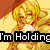 Pixelated anime-style character with blonde hair in a yellow outfit, holding a white object against a warm-toned background with text overlay.