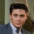 A pixelated image of a person in a suit with a blue background containing text elements.