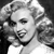 Black-and-white pixelated image of a person with styled hair, closed eyes, and a slight smile, wearing a light-colored garment against a dark background.