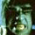 Pixelated green and blue image of a character with dark hair, light eyes, and a blurred background.