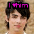 Pixelated image of a person with dark hair and light skin, wearing white clothing, overlaid with pink text reading "I ❤️ him" on a black background.