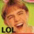 Pixelated image of a person with light brown hair and closed eyes, smiling broadly against a green background with black text reading LOL at the bottom left.
