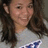 Pixelated close-up of a person with long dark hair wearing a light-colored shirt with blue and white patterns.