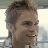 A pixelated image of a person with short brown hair and light skin, next to green text reading 'OriginalIcons.com' on a dark background.