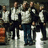 Group of six pixelated figures in formal attire standing in a row with varied poses and expressions.