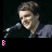 Animated contact sheet of a person speaking at a microphone with evolving text and heart symbols below the frame.