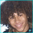 A pixelated image of a person with voluminous curly hair, smiling broadly in two side-by-side frames showing slight facial expression changes.
