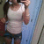 Pixelated static image of a person in a white sleeveless top and dark shorts, holding a phone to their ear against a blue and gray background.