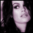 Pixelated static image of a person's face with dark hair and light skin tones on a black background, rendered in low-resolution 8-bit style.