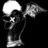 Black-and-white pixelated image of a skeletal figure with wings and a glowing head, surrounded by pixelated text fragments.