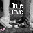 Pixelated grayscale image with white text 'True Love' centered over a blurred background of indistinct shapes and light/dark gradients.