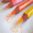 Animated sequence showing colored pencils, a heart outline on metallic surface, and rainbow-colored frame with white shape.