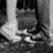 Black-and-white pixelated image of a person's lower legs and feet standing on a textured surface, with red text 'connor' and a heart symbol in the upper right.