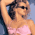 Static pixelated image of a woman in a pink bikini top with dark hair, wearing sunglasses against a light blue background.