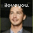 Pixelated image of a person with short hair wearing a light-colored shirt under a dark jacket, with text above the head.