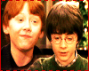 Two individuals with distinct hair colors stand side-by-side next to a chessboard scene featuring large wizard-themed pieces and green text.