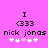 Pixelated text and symbols on a bright pink background with two identical static frames showing 'I (333 nick jonas' and four white plus signs below.