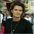 A pixelated image shows a person with dark hair wearing a black top, positioned next to blue text reading 'Orlando Bloom' on a black background.