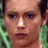 Pixelated image of a woman's face with green hair and the word "CHARMED" in pixelated text on a dark background.