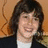 A pixelated image of a person with dark hair wearing a dark jacket over a white shirt, next to blue text reading 'Ily Nat!' on a white background.
