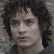 Pixelated close-up of a person with dark curly hair, neutral expression, and light skin tone against a muted background.